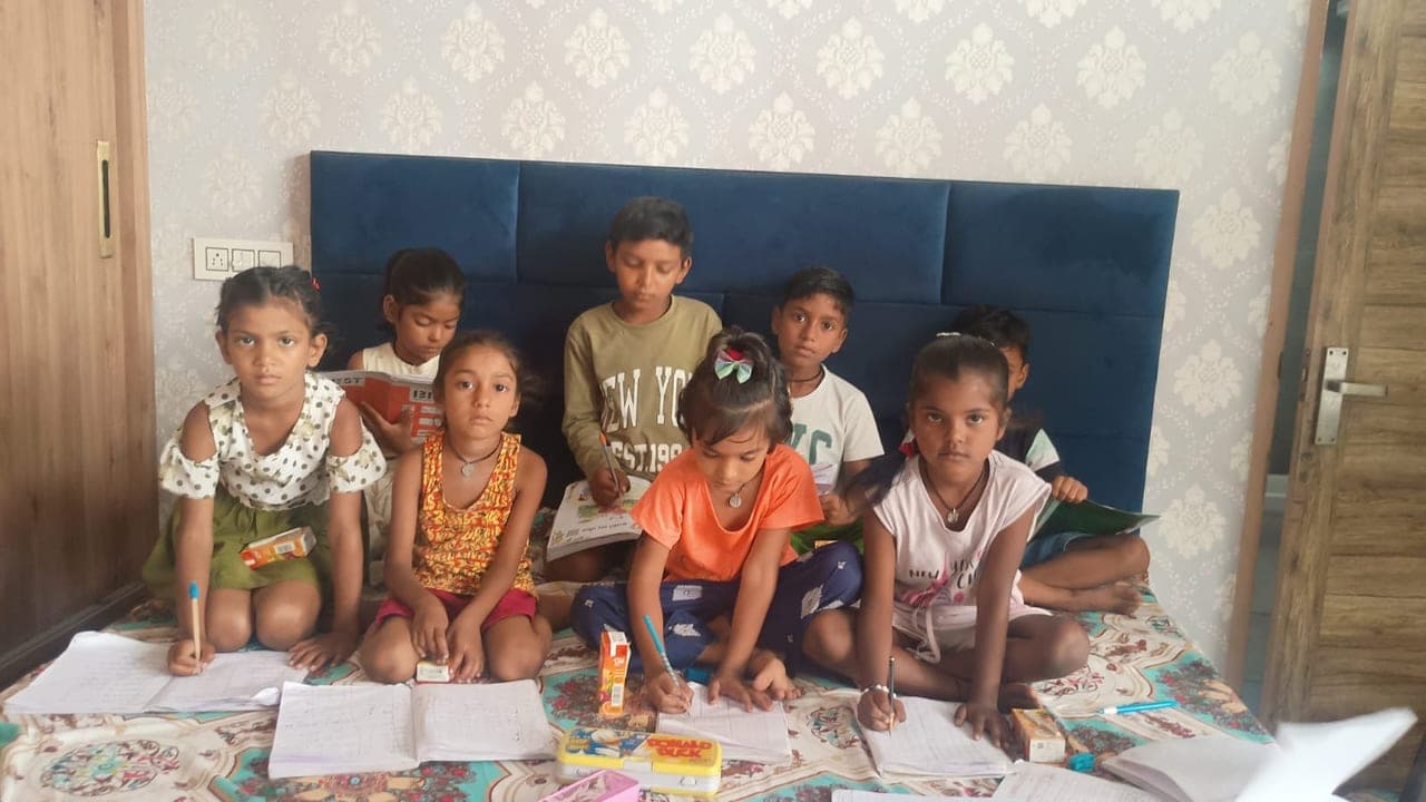 Children writing in their notebooks during a study session funded through Al Ranim Properties channel partners in India