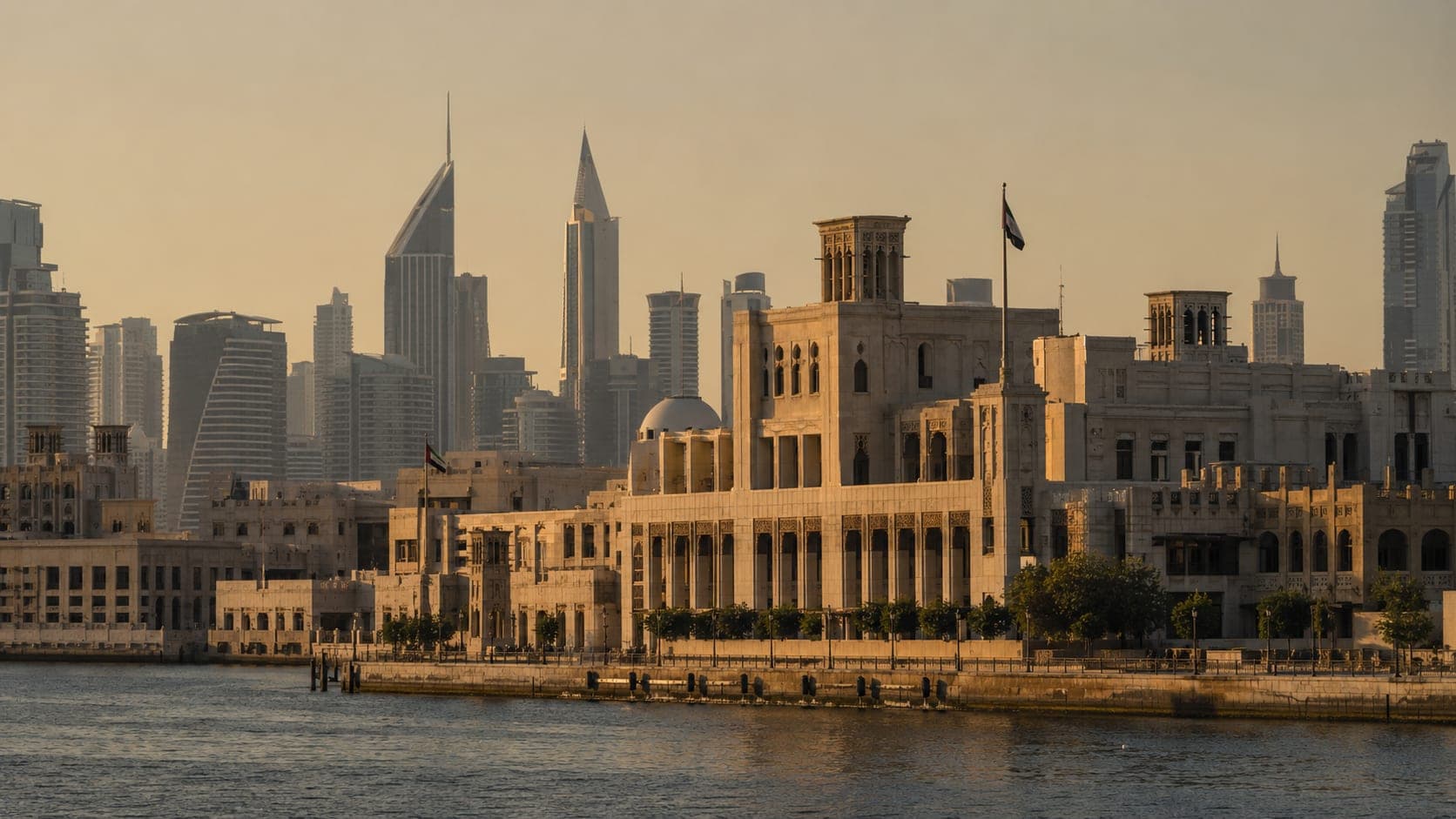 Dubai Creek at golden hour with the historic civic district in front of the modern skyline, where the Dubai Land Department registers property ownership
